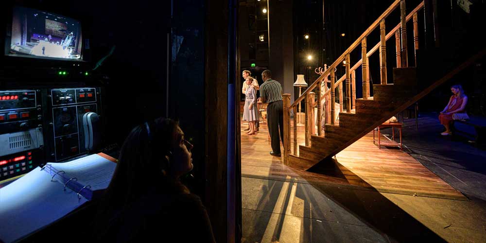 A stage manager calling a performance of Clybourne Park, directed by Lindsay Posner